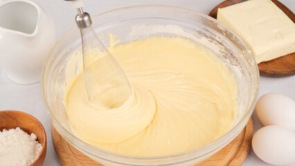 Kneading the dough with a whisk of a blender in bowl. Chef Mix liquid dough for pancakes or cake with a blender