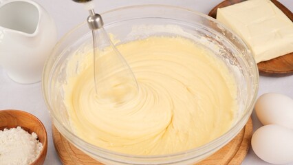 Kneading the dough with a whisk of a blender in bowl. Chef Mix liquid dough for pancakes or cake with a blender