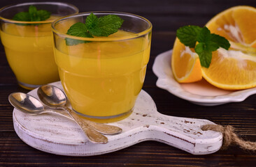 Orange cream (English citrus cream) in a glass on a dark wooden background.
