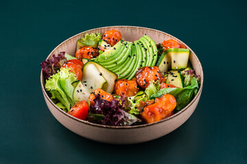 Fresh salad with sweet and sour chicken, avocado, tomato, zucchini, lettuce and sesame seeds in a bowl.