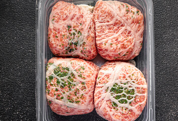 meat cutlet in fat grid fatty mesh pork, beef raw minced meat and spice fresh snack meal food snack on the table copy space food background rustic top view