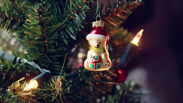 Ein goldener Eisb&auml;r mit roter M&uuml;tze h&auml;ngt als Schmuck am Christbaum