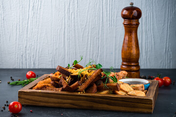 Beer set for party: onion rings, croutons, potato wedges, chicken legs and sauce.
