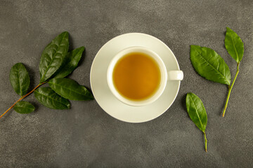 Tea leaves with a white cup of green tea,on black background
