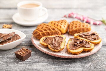 Homemade waffle with chocolate butter on a gray wooden. side view, selective focus.