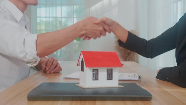 Closeup hands of real estate agent and customer handshake together after agreement together about credit house and insurance, client and consulting of investment about residential, business concept.