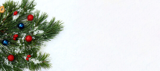 Fototapeta na wymiar New Year's concept: a composition of pine branches with long needles and Christmas balls, artificial snow. Photo for creating greeting banners