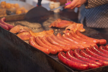 Street food in a large pan and grill at the market. The pan is smoking.