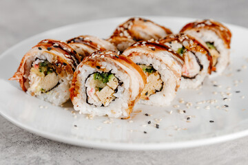 Eight servings of shrimp and eel sushi on a white plate.