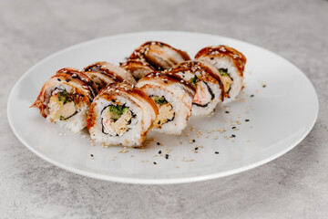 Eight servings of shrimp and eel sushi on a white plate.