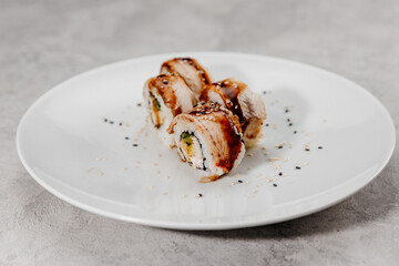 Four portions of sushi with shrimp and eel on a white plate.Side view
