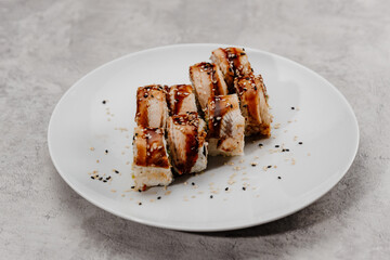 Eight servings of shrimp and eel sushi on a white plate.