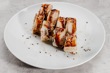 Eight servings of shrimp and eel sushi on a white plate.
