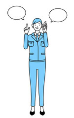 電話をしながら指さしをする作業着を着たシニア女性（経営者、管理職、工場長）