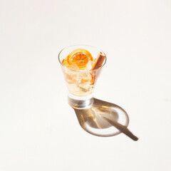 Winter drink mocktail with cinnamon and dry orange on a cream background.
