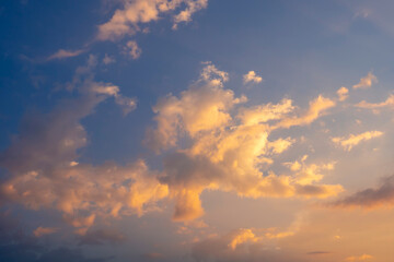 Colorful sunset. Yellow-orange clouds in the blue evening sky.