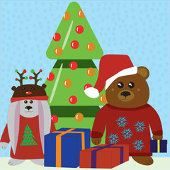 A little bear in a sweater with snowflakes and a Santa hat and a bunny in a Santa reindeer hat near the Christmas tree