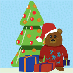 A little bear in a sweater with snowflakes and a Santa hat near the Christmas tree