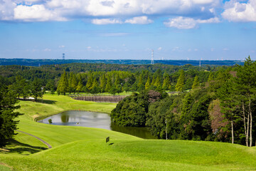 青空のゴルフ場・池や多数のコブがある打ち下ろしで難しいコースの眺め（千葉県木更津市）
