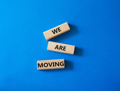 We are moving symbol. Concept word We are moving on wooden blocks. Beautiful blue background. Business and We are moving concept. Copy space