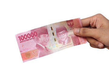 Hand holding one hundred thousand rupiah banknote isolated on a white background. financial concept