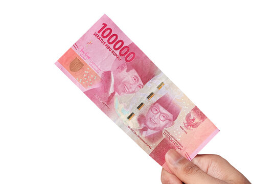Hand holding one hundred thousand rupiah banknote isolated on a white background. financial concept