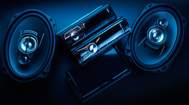 Black car sound speakers and radio tape recorder close-up on black background, audio system, hard bass subwoofer, control panel
