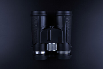 New binoculars isolated on black background. Flat lay, top view