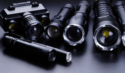 Set of black pocket tactical flashlights isolated on black background - obrazy, fototapety, plakaty