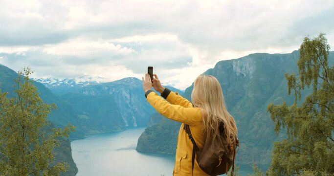 Travel influencer, phone photo and woman on freedom holiday, winter hiking and adventure in Norway. Nature trekking, social media update and girl with mobile video on vacation in the mountains
