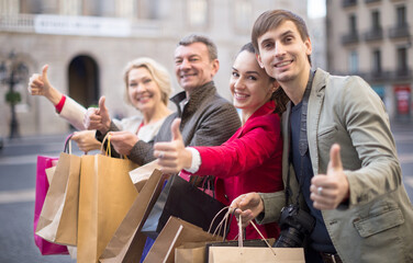 parents with older children rejoice with many shopping packages after successful shopping
