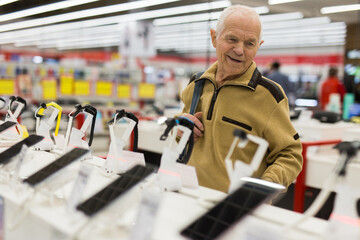 senor man pensioner buying modern smart watch in showroom of digital electronic goods store