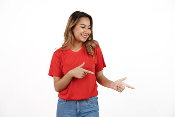 Studio shot of pretty Asian woman with red t-shirt isolated on white background. Pointing blank area