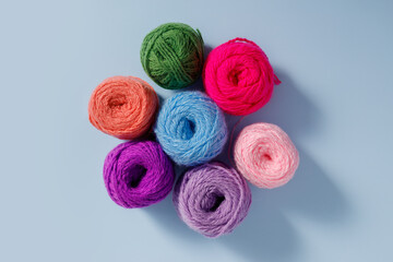 Skeins of multi-colored woolen threads isolated on a blue background.