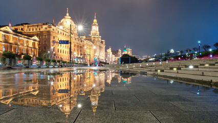 Shanghai bund landscape in rainy day, perfect reflection of historical building landmarks in puddles on sidewalks. - Powered by Adobe