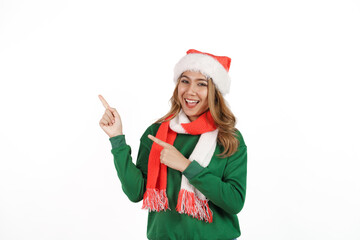 Attractive excited asian female in green sweater with santa hat on christmas isolated on white background. Pointing hand