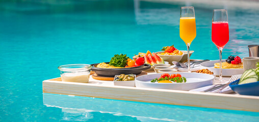 Breakfast in swimming pool, floating breakfast in luxurious tropical resort. Table relaxing on calm...