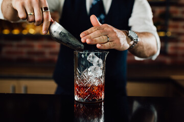 Slowly adding ice into the glass