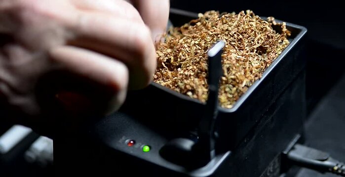 The process of putting tobacco into cigarette cases with a semi-automatic machine