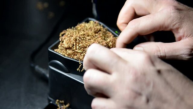 The process of putting tobacco into cigarette cases with a semi-automatic machine