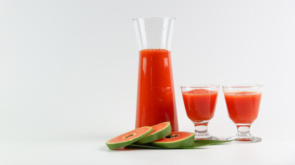 Papaya smoothie in glass jar and glasses on white background diet vegetarian healthy and freshness drink concept soft and selective focus