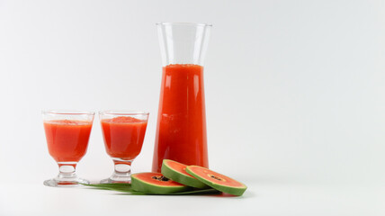 Papaya smoothie in glass jar and glasses on white background diet vegetarian healthy and freshness drink concept soft and selective focus