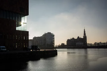 Foto op Canvas A silhouette accross the water catching the edge of the museum Aan de Stroom in the port of Antwerp Bruges portopolis and St Pauls church or sint pauluskerk in Flemish © drew