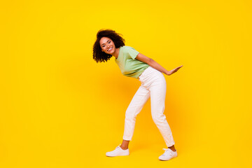 Fototapeta na wymiar Full size photo of young gorgeous nice pretty woman wear casual summer clothes hold heavy object positive showing strong isolated on yellow color background