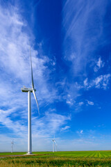 Fototapeta na wymiar Modern windmills for energy transition in typical Dutch agricultural landscape, Netherlands.