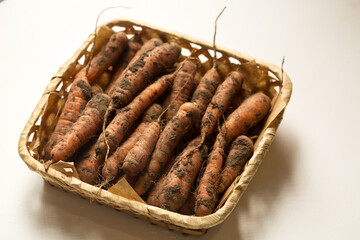 carrots in a square basket on a white background