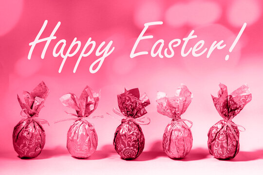 Trendy toned in color 2023 Viva Magenta Easter card with wrapped Easter eggs and words Happy Easter