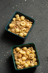 Dry granola in square bowls on a gray background
