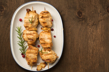 Chicken kebab with lingonberry sauce on a dark background, top view