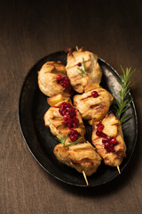 Chicken kebab and lingonberry sauce on a dark